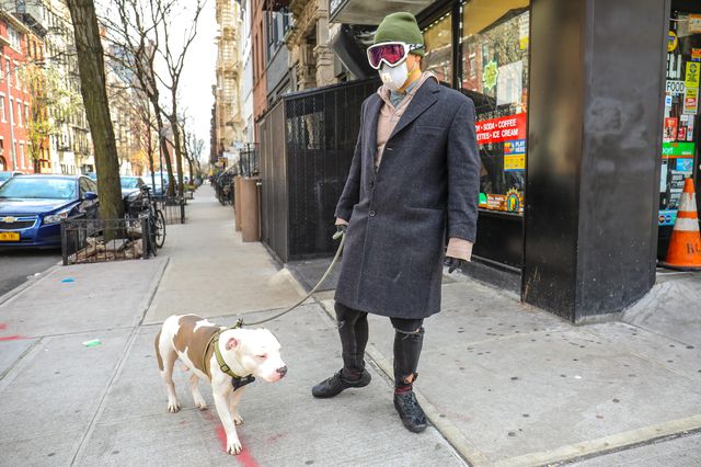 A man walking his dog wears a face mask in New York City.